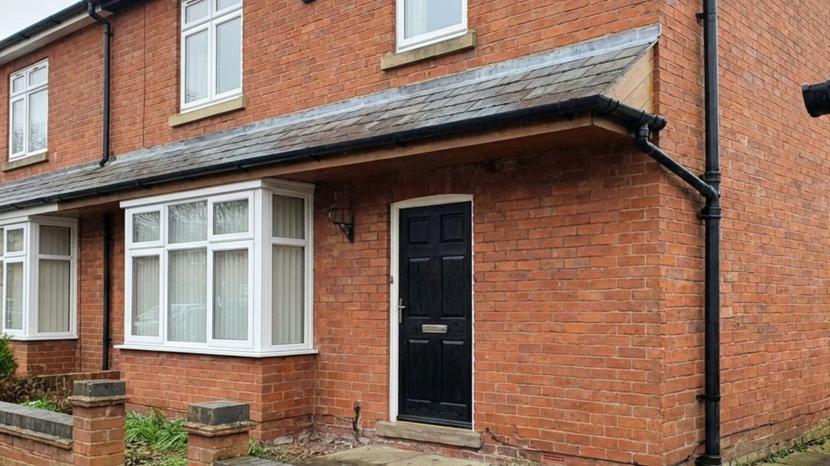 Black guttering and downpipe on a brick house