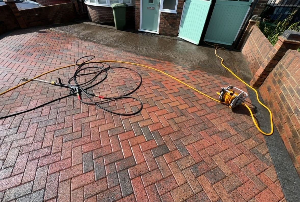 Freshly power washed herringbone block paving