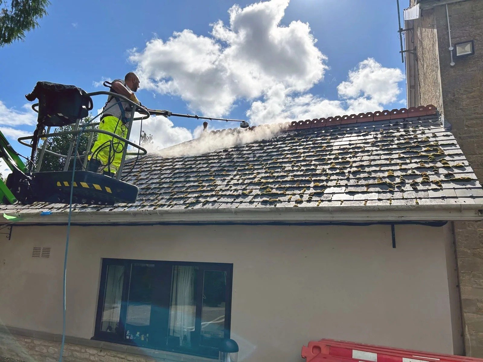 Roof cleaning from a cherry picker